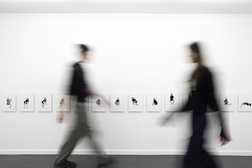 Régime d’assise, vue d’installation à Contretype, Bruxelles, des visiteur·euses passent devant la série